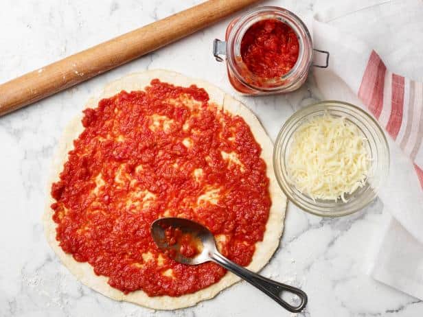 Putting sauce on the pizza dough