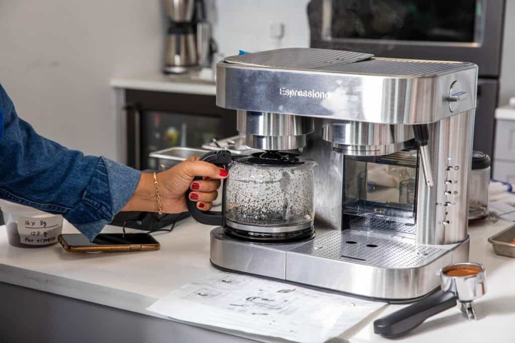 A woman brewing coffee in espresso machine